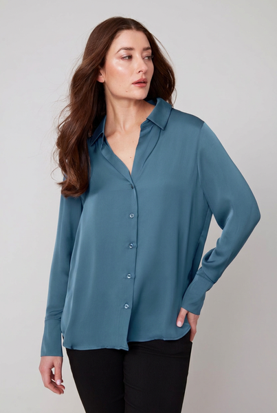 Female model wearing a teal long sleeve sateen blouse with black trousers